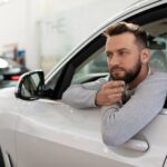 a man, when buying a new car in a car dealership, thought about an insurance policy for a driver